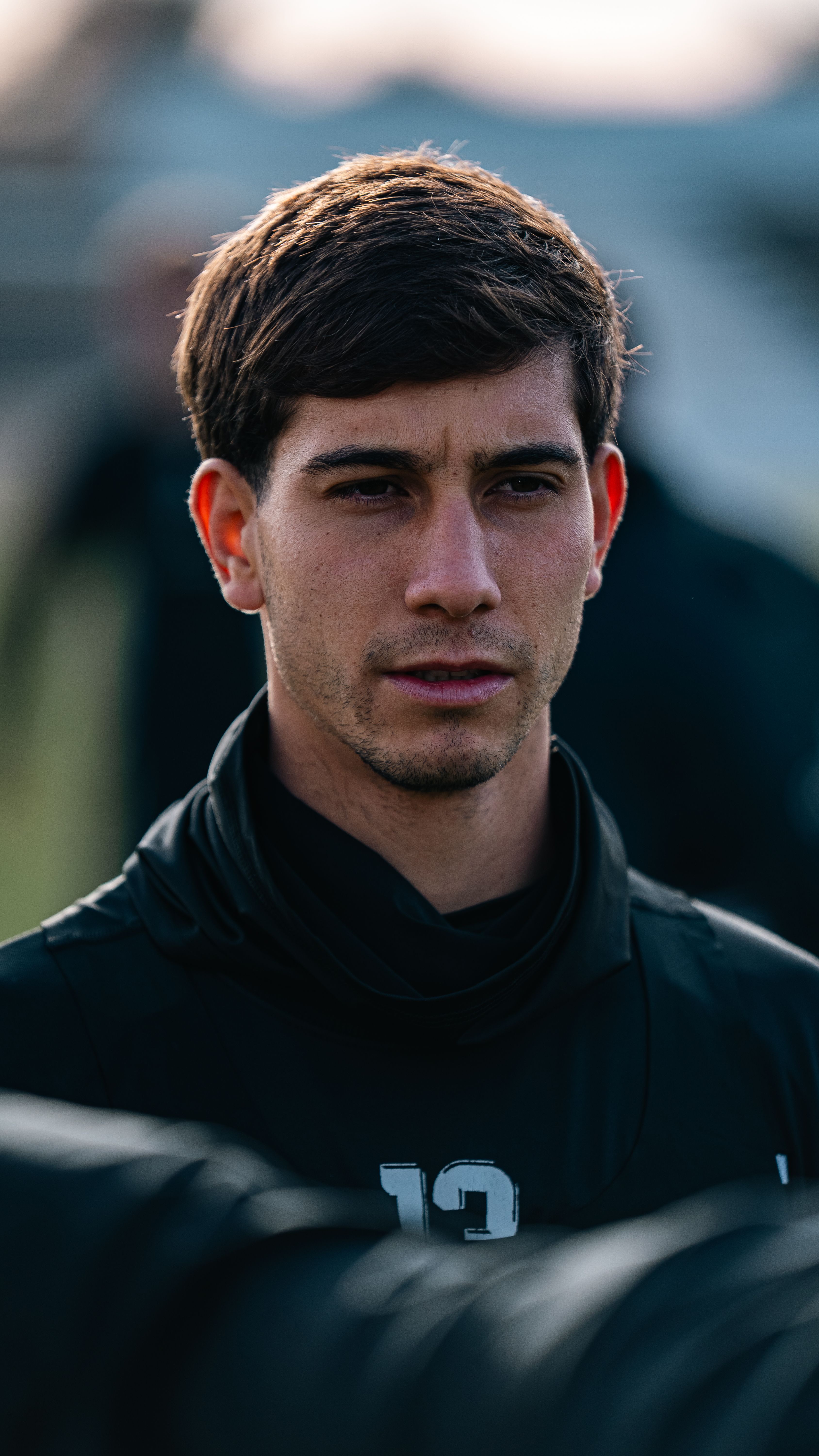 Focused young athlete during outdoor training session, wearing sportswear, with number 13.