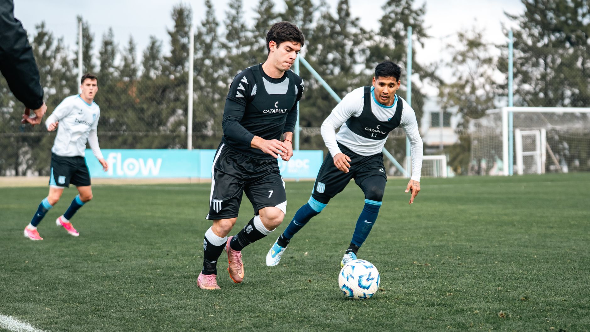 Players engage in dynamic soccer training on a lush green field, honing their skills and strategies.