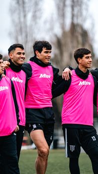 Group of male athletes enjoying a team bonding session on a football field.