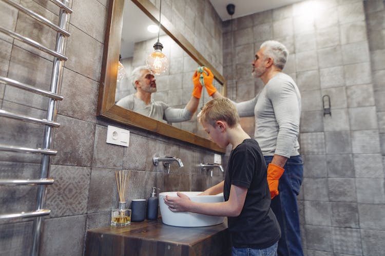 Dad With Kid Tidying Up Bathroom