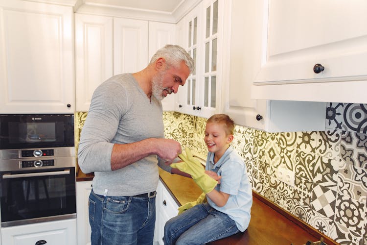 Happy Father With Cheerful Son At Kitchen