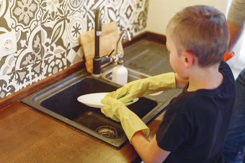 Free Diligent Young Boy Cleaning the Dishes Stock Photo