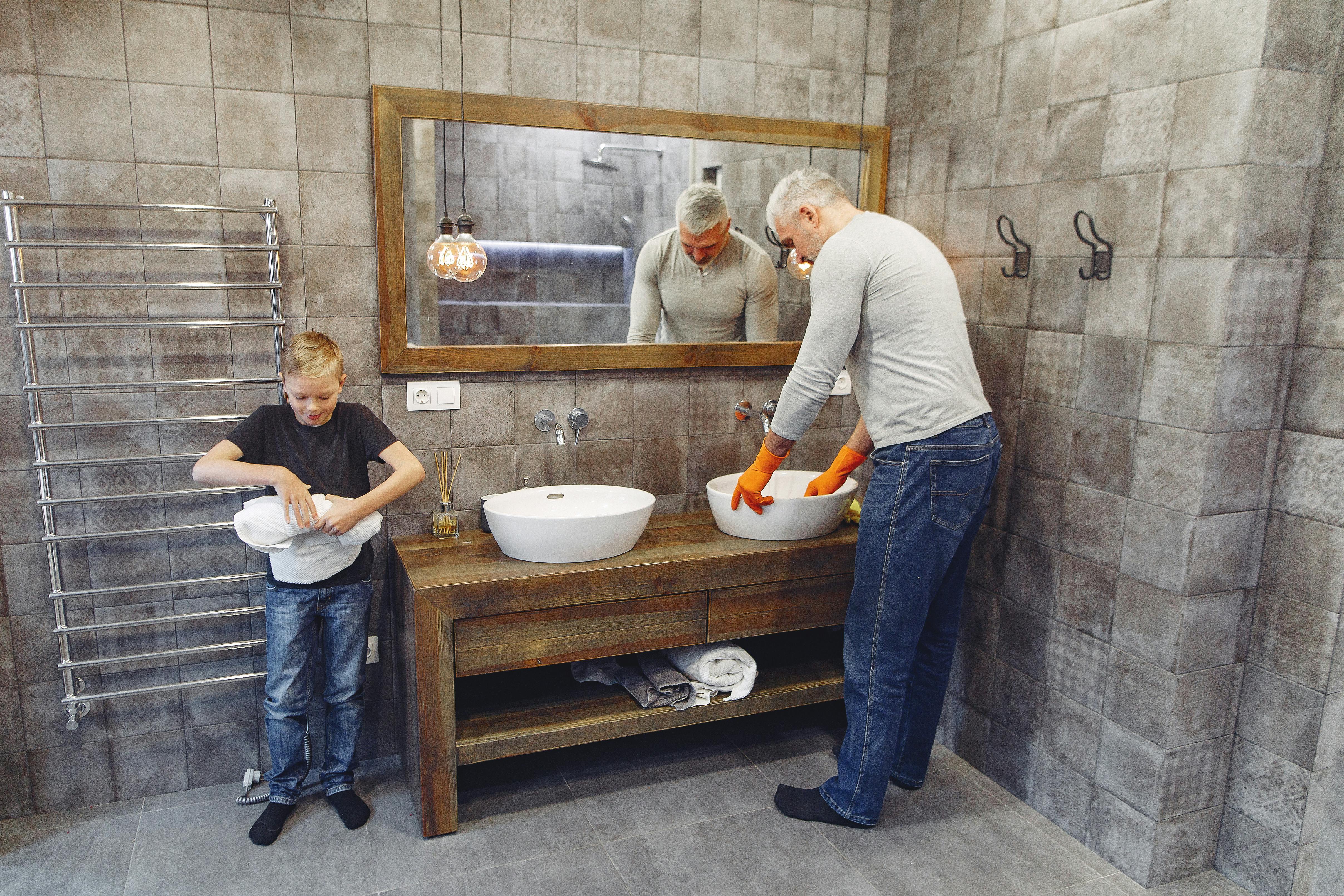 dad and son tidying up bathroom