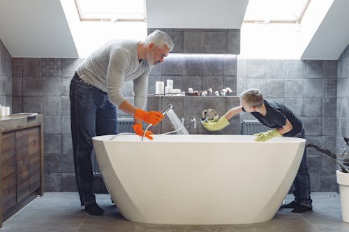 Free Father and son tidying up bathroom together Stock Photo