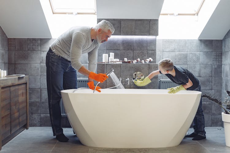 Father And Son Tidying Up Bathroom Together