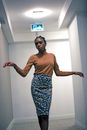 Young black woman dancing in hallway of modern building