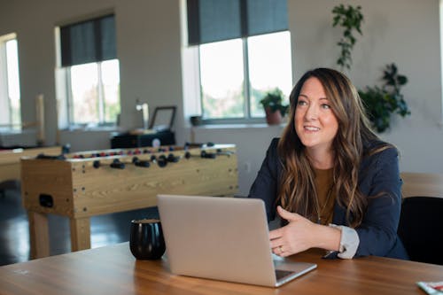 A Woman Wearing a Black Blazer Sitting in front of a Laptop