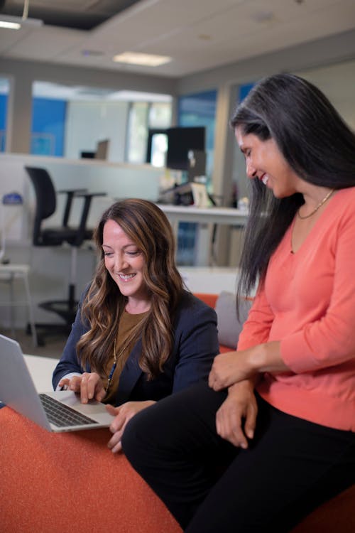 Smiling Women Looking at the Screen of a Laptop