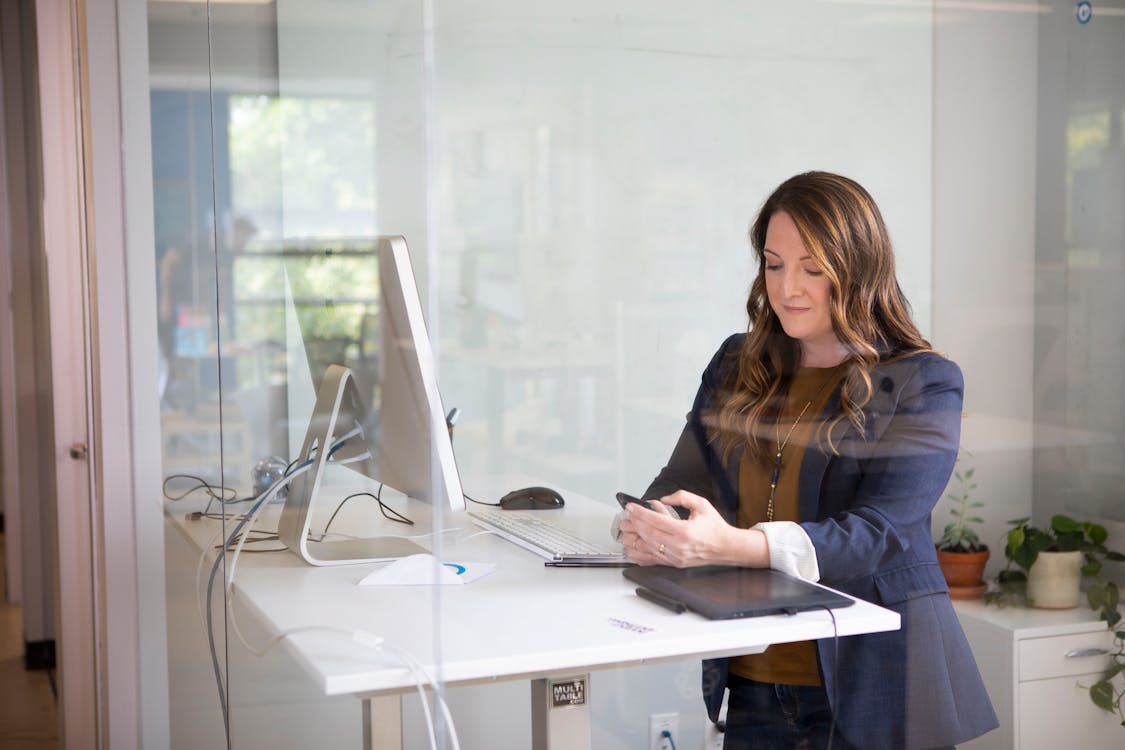 Free A Woman Wearing a Blazer using a Smartphone Stock Photo