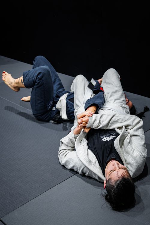 Free Two athletes practicing Brazilian Jiu-Jitsu grappling in a gym setting. Stock Photo