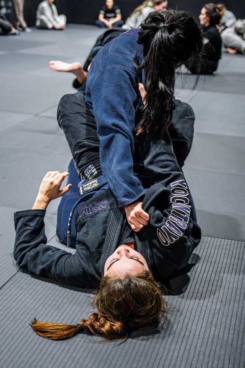 Free Two women engaging in Brazilian Jiu-Jitsu practice in a gym setting. Stock Photo