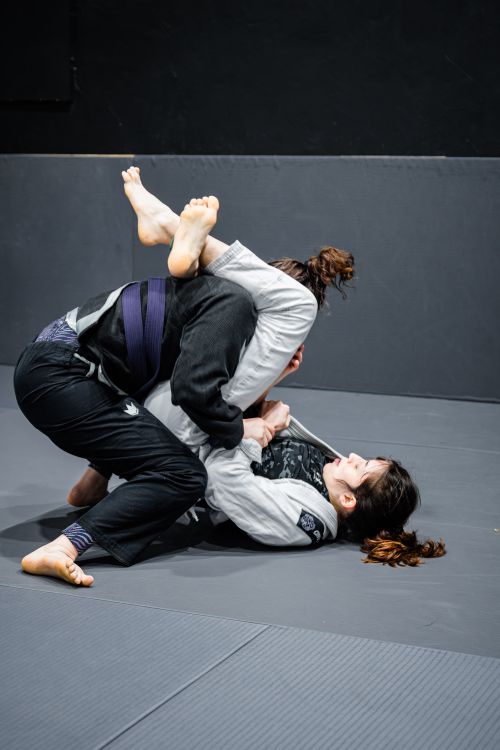 Free Two athletes engaged in a dynamic jiu-jitsu training session indoors, showcasing skill and agility. Stock Photo