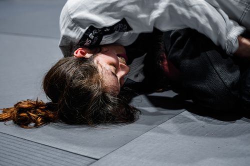 Free Close-up of two women engaged in Brazilian Jiu-Jitsu training on a mat. Stock Photo