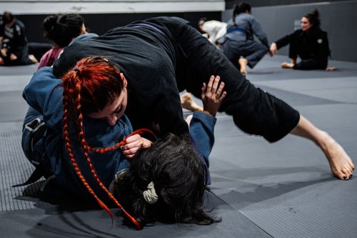 Free An intense martial arts session with practitioners grappling on mats indoors in Buenos Aires. Stock Photo