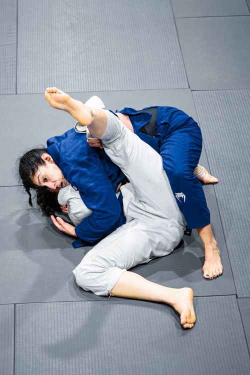 Free Two athletes grapple in a Brazilian Jiu-Jitsu match on the mat, showcasing skill and technique. Stock Photo