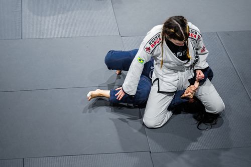 Free Two women engaged in a Brazilian Jiu-Jitsu match showcasing grappling techniques on the mat. Stock Photo