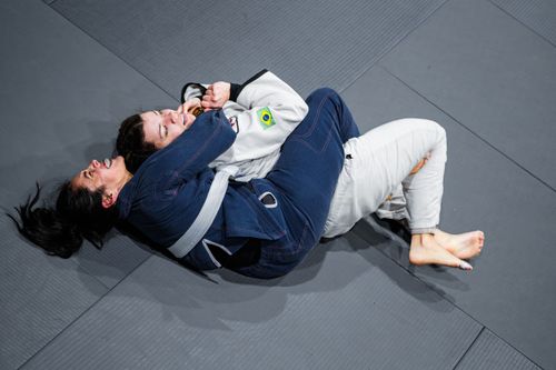 Free Two women practice Brazilian Jiu-Jitsu techniques on a mat in Buenos Aires, showcasing skill and focus. Stock Photo