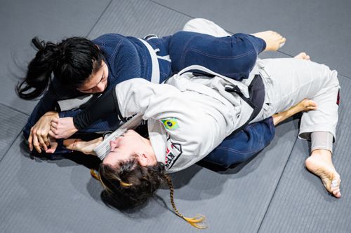 Free Female athletes engage in a Brazilian Jiu-Jitsu hold during training in Buenos Aires. Stock Photo