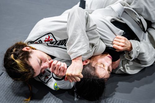 Free Two martial artists in white gis engage in an intense Brazilian Jiu-Jitsu match on the mat. Stock Photo