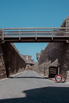 View of ancient stone walls and a wooden bridge in Saint-Malo, Brittany, France under clear skies.