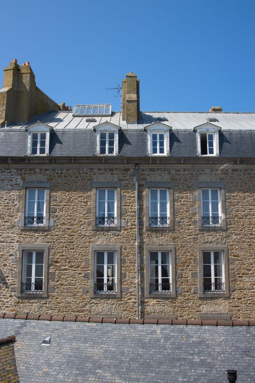 Free Traditional stone building facade in sunny Saint-Malo, Brittany, France. Stock Photo