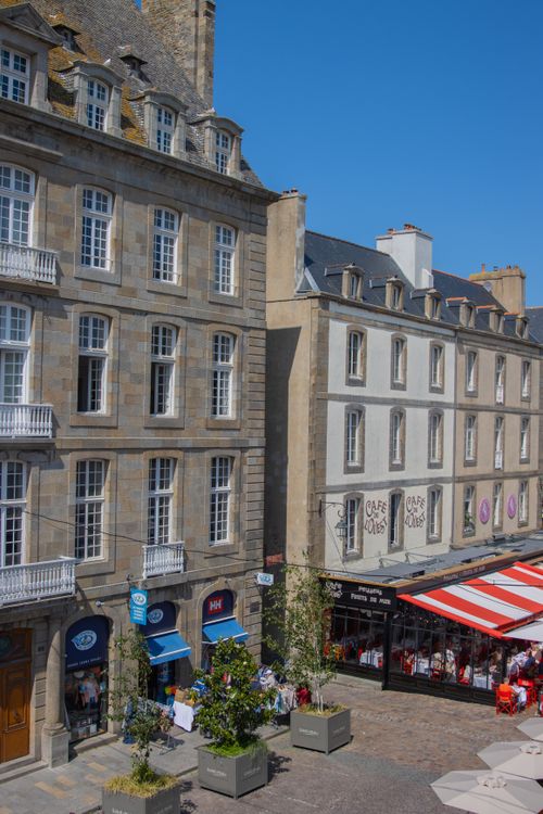 Free Charming street in Saint-Malo, Brittany with classic architecture and vibrant cafe awnings. Stock Photo