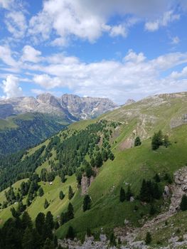 Breathtaking view of a green mountain valley under a bright blue sky.