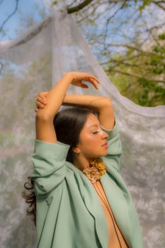 A serene portrait of a woman outdoors in Berlin, showcasing elegance and springtime foliage.