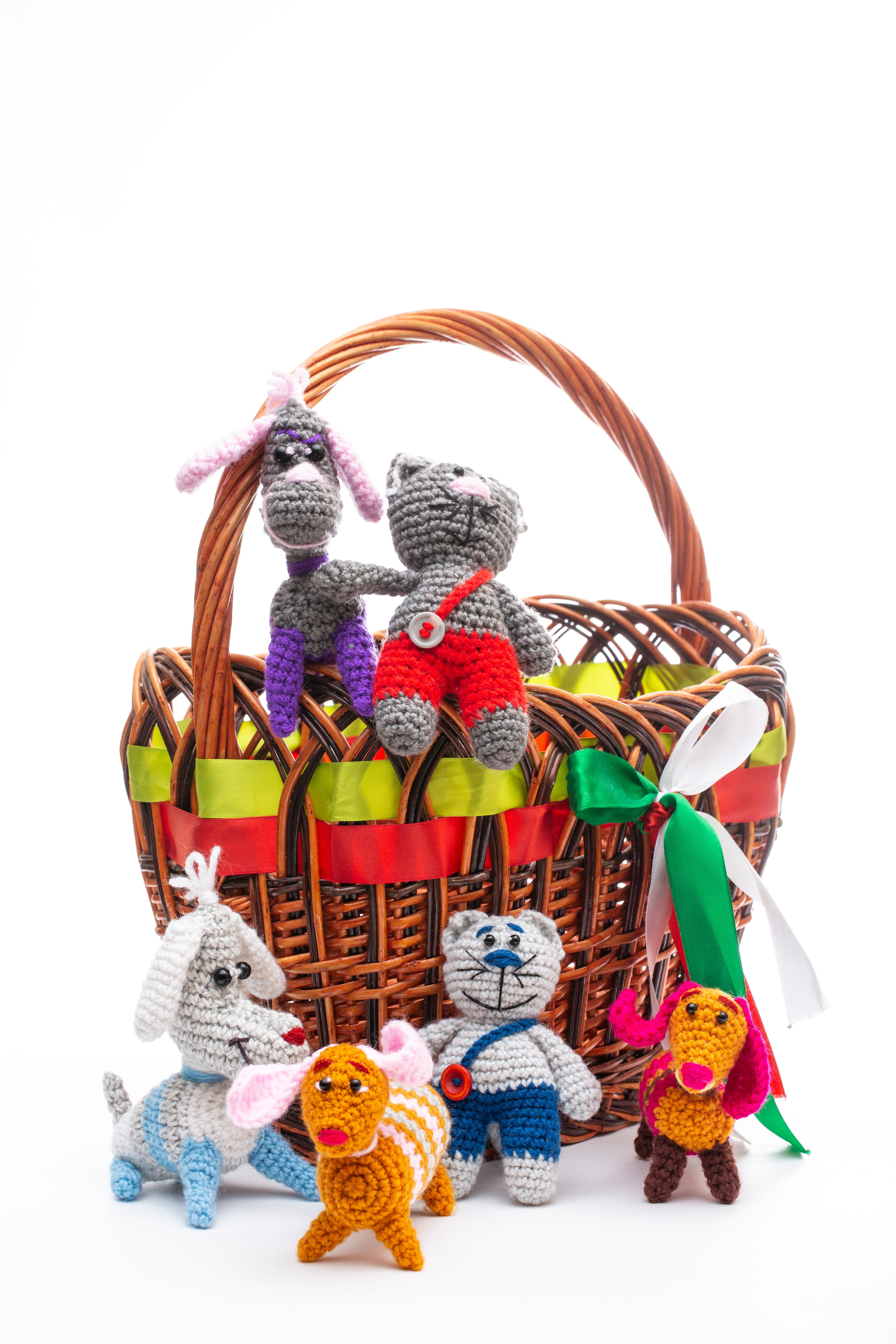 Vibrant amigurumi animal toys displayed in a decorative wicker basket, perfect for gifting.