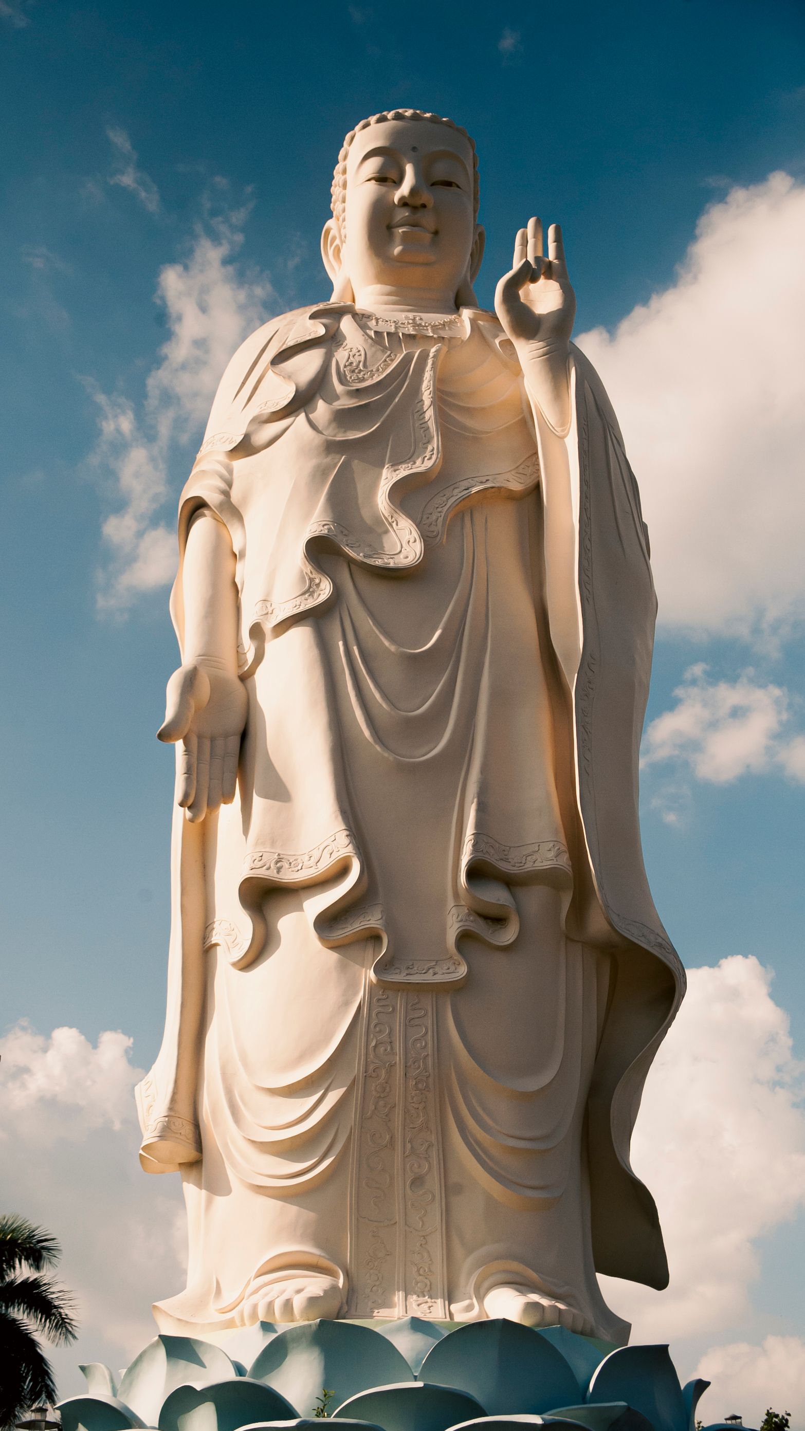 A towering Buddha statue under a clear blue sky in My Phong, Vietnam showcasing serene beauty.
