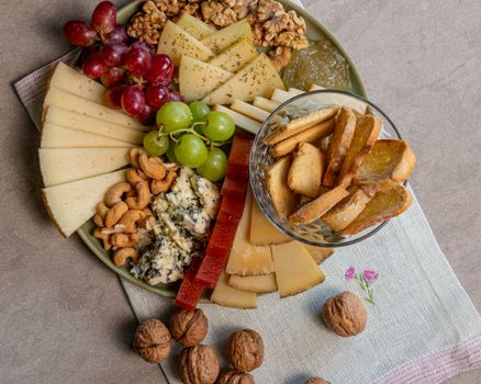 A delicious artisanal cheese platter with nuts, grapes, and bread, perfect for gourmet appetizers.