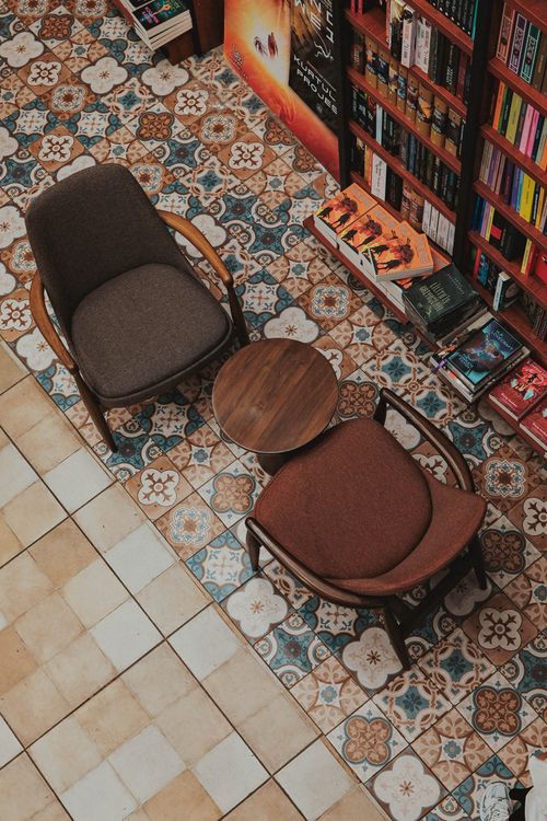 Free Top view of a cozy reading corner with vintage armchairs and patterned tiles, ideal for relaxation. Stock Photo