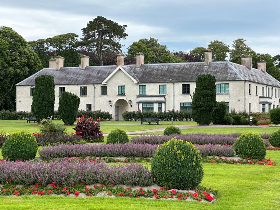 A white country house with clipped box and lavender beds