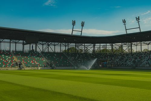 Free Panoramic view of an empty football stadium in Sosnowiec, Poland, under a clear blue sky. Stock Photo