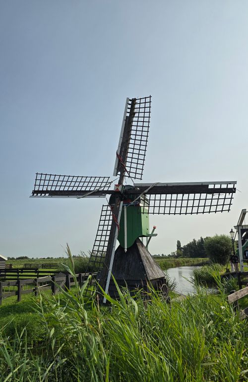 Free Traditional Dutch windmill surrounded by scenic greenery, capturing the essence of rural Netherlands. Stock Photo