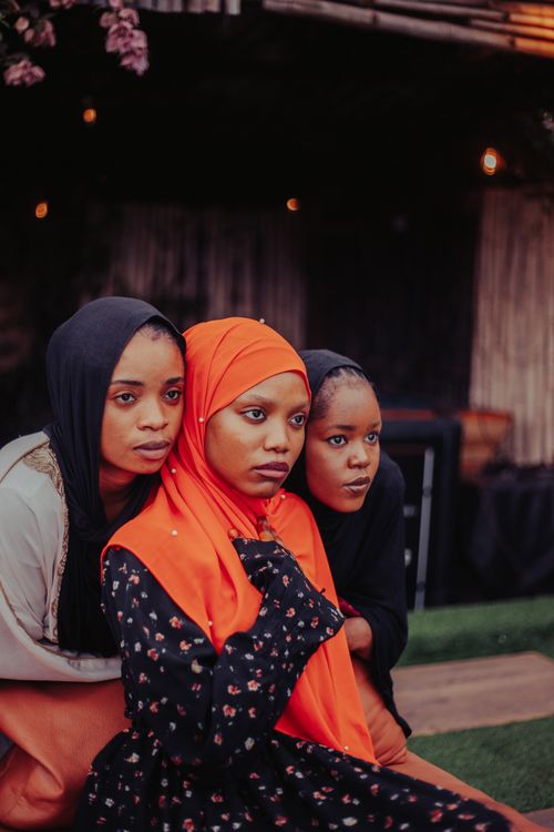 Free Three women in colorful hijabs pose closely outdoors, showcasing unity and cultural diversity. Stock Photo