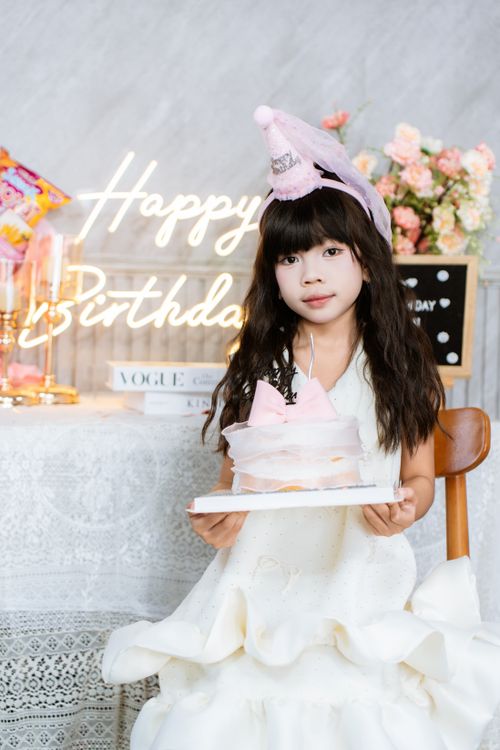 Free A young girl smiles with her birthday cake during a festive celebration indoors. Stock Photo