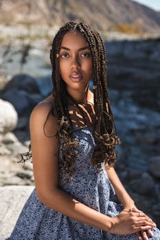 一位年轻女子梳着辫子，坐在户外阳光下