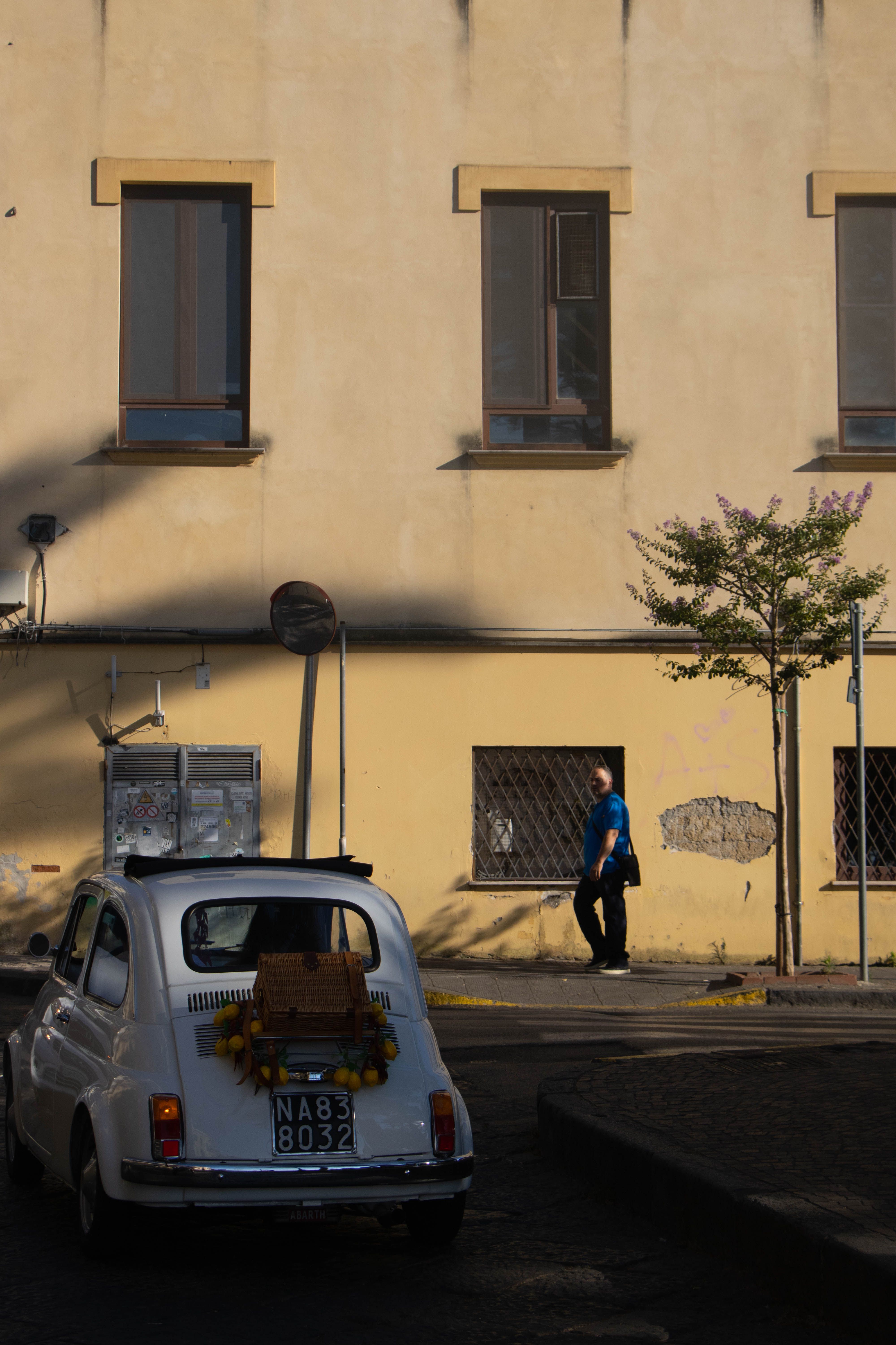 Charming vintage car in Sorrento, Italy, with a sun-dappled street scene and classic architecture.