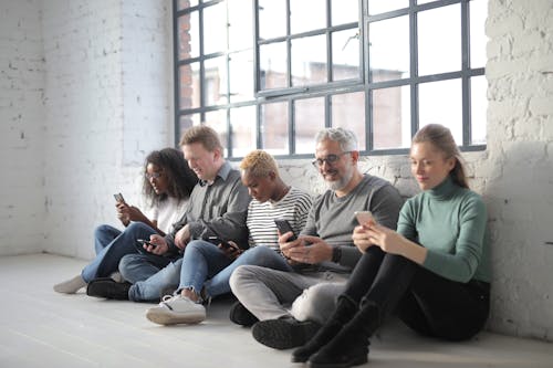 Diverse people surfing internet on smartphone in afternoon