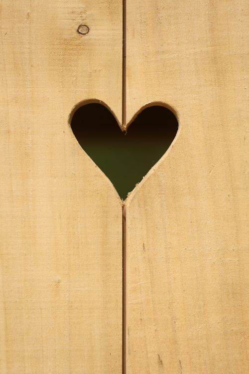 Free Heart-shaped cutout in a wooden fence, perfect for love or Valentine's themes. Stock Photo
