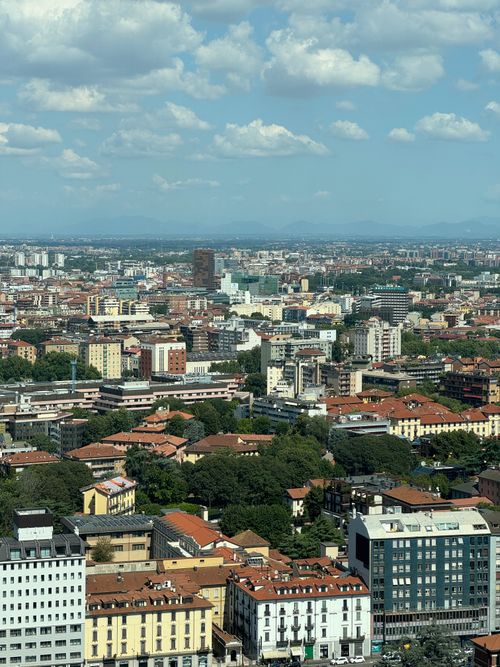 Free Aerial view of Milan showcasing historic architecture and modern skyline under a bright sky. Stock Photo