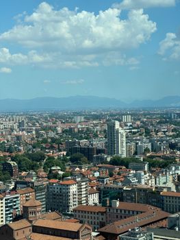 Stunning aerial view of Milan, showcasing its urban architecture under a bright blue sky.
