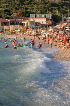 Vibrant sunset beach scene with people enjoying the waves and shoreline