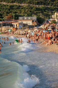 A lively beach scene with people enjoying the sun and sea on a summer day.