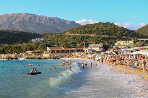Free Crowded beach scene with tourists enjoying the sea under a clear summer sky. Stock Photo