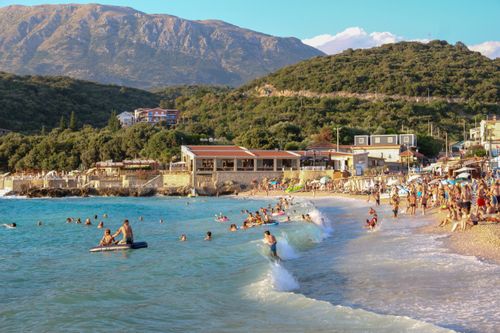 Free A lively beach scene with people enjoying the sun and sea in a coastal town during summer. Stock Photo