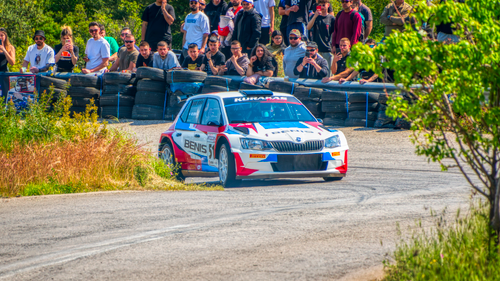 Free Rally car navigates a tight corner at a thrilling race event in Ritsona, Greece, surrounded by a crowd. Stock Photo
