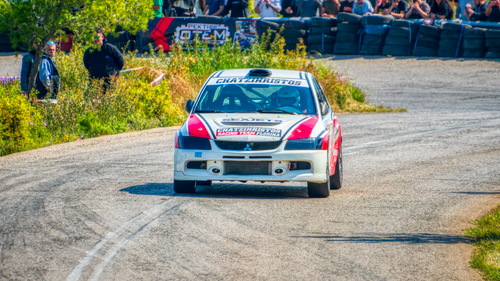 Free Racing car speeding through a rally track in Ritsona, Greece with spectators in background. Stock Photo