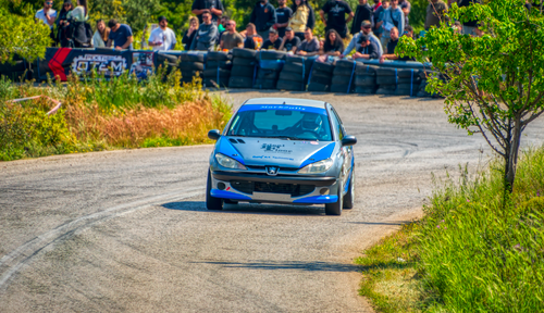 Free Dynamic image of a rally car on a winding road in Ritsona, Greece with spectators. Stock Photo
